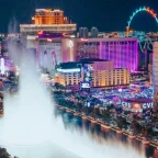 overhead view of the Bellagio fountain show on the Las Vegas Strip at dusk with glowing hotel signs