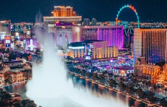 overhead view of the Bellagio fountain show on the Las Vegas Strip at dusk with glowing hotel signs