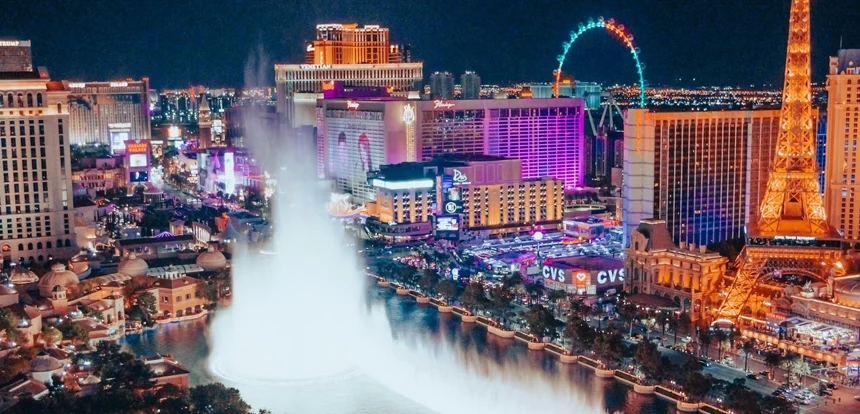 overhead view of the Bellagio fountain show on the Las Vegas Strip at dusk with glowing hotel signs