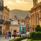 Traveler browsing a local street on a bright cobblestone street lined with colorful colonial buildings in Mexico