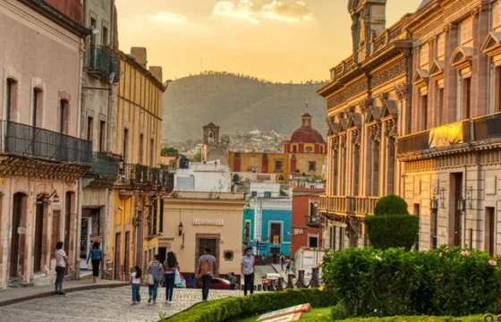 Traveler browsing a local street on a bright cobblestone street lined with colorful colonial buildings in Mexico