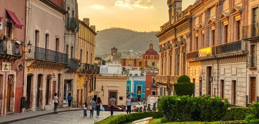 Traveler browsing a local street on a bright cobblestone street lined with colorful colonial buildings in Mexico
