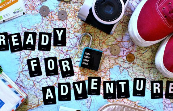 verhead flat lay of road trip planning essentials including a paper map