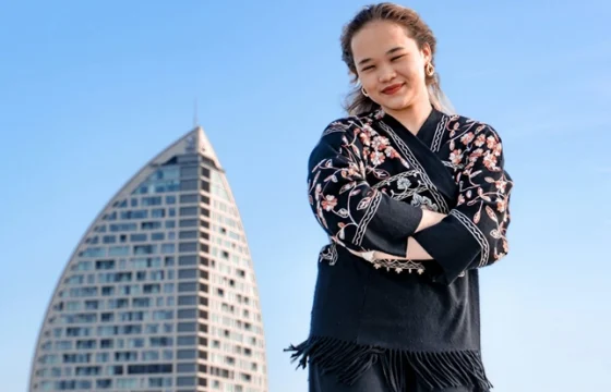 Solo female traveler at a city viewpoint looking confidently at a panoramic cityscape