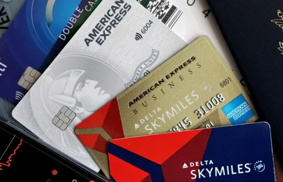 Overhead flat lay of a travel rewards credit card, boarding pass, passport
