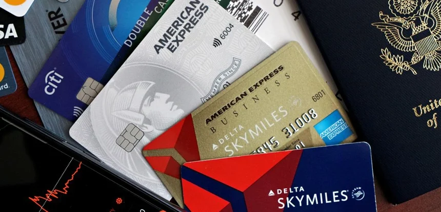 Overhead flat lay of a travel rewards credit card, boarding pass, passport