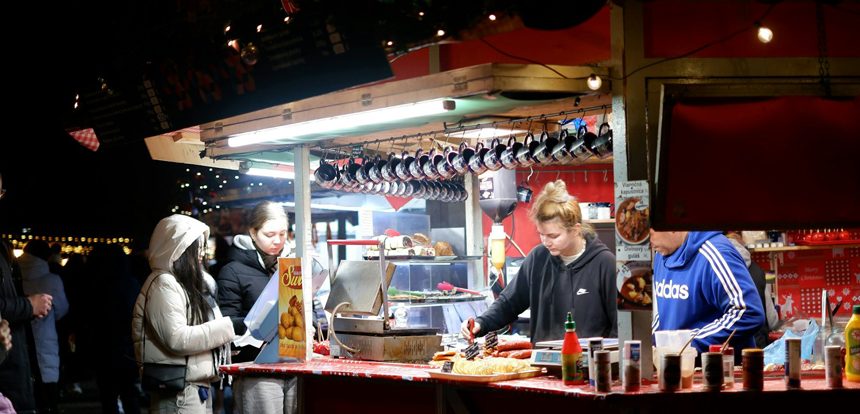 Traveler at a small outdoor food stall waiting to enjoying a local meal at a busy market food stall