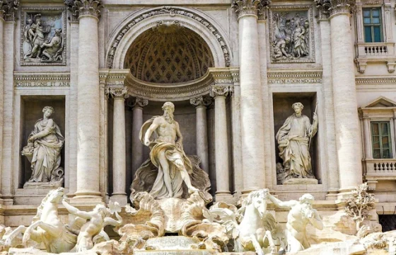 Trevi Fountain in Rome with golden stone architecture and clear turquoise water on a bright day