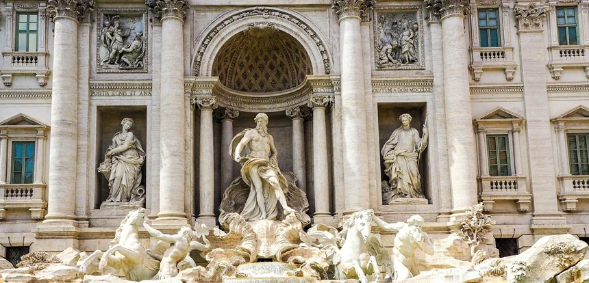 Trevi Fountain in Rome with golden stone architecture and clear turquoise water on a bright day
