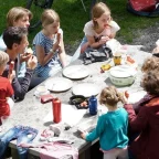 Family picnic with sandwiches and snacks at a roadside picnic stop during a budget road trip