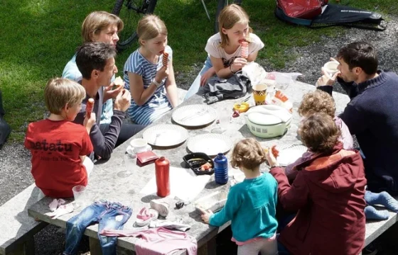 Family picnic with sandwiches and snacks at a roadside picnic stop during a budget road trip