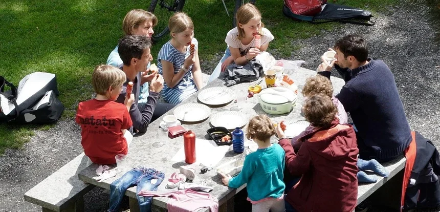 Family picnic with sandwiches and snacks at a roadside picnic stop during a budget road trip